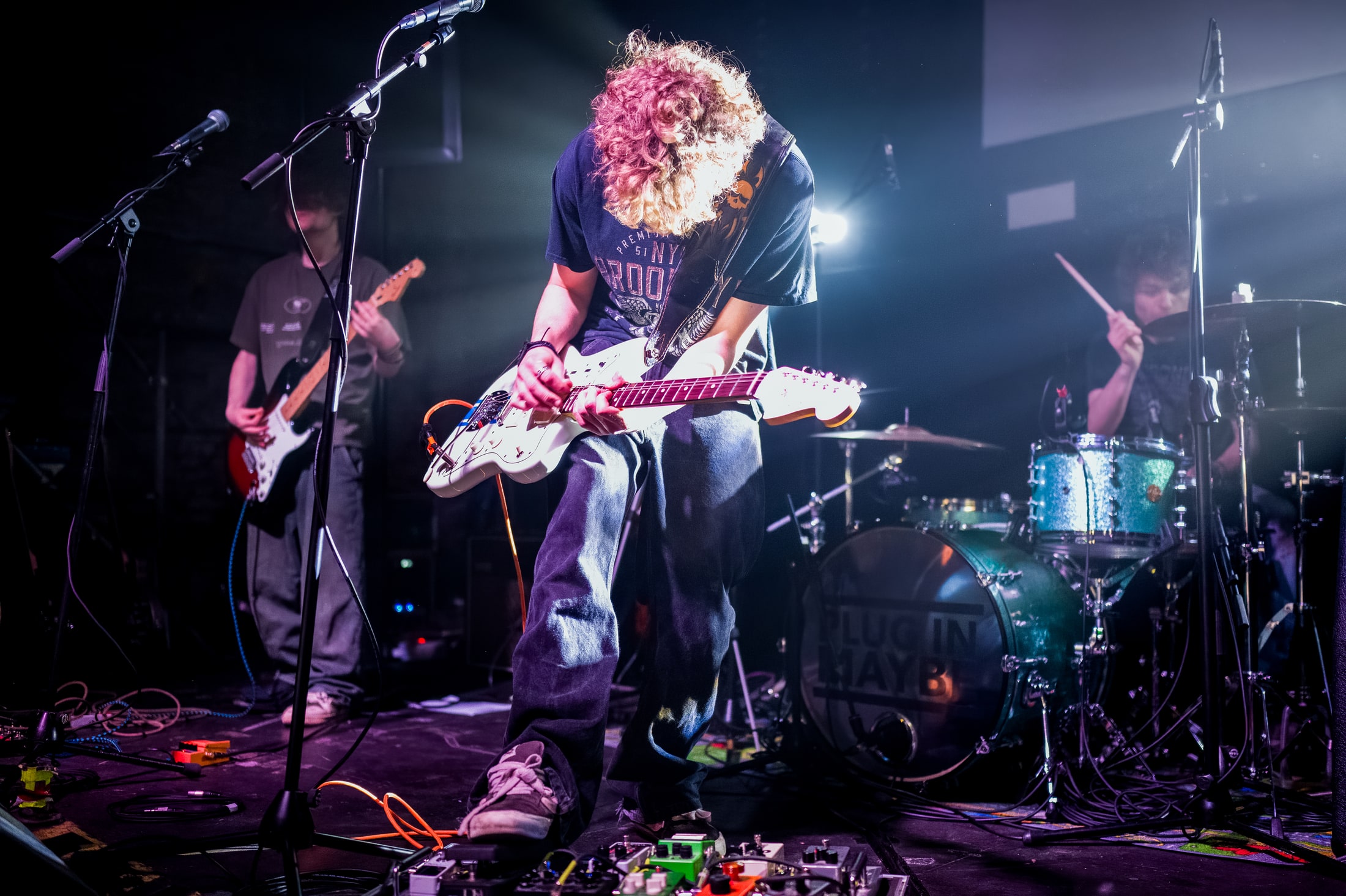 An Aphid guitarist performing under the stage lights